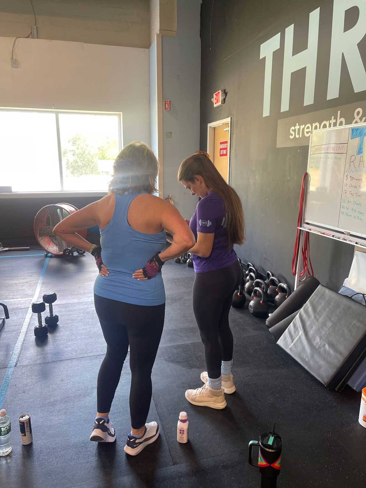 Thrive Group Strength Training member consults with a personal trainer